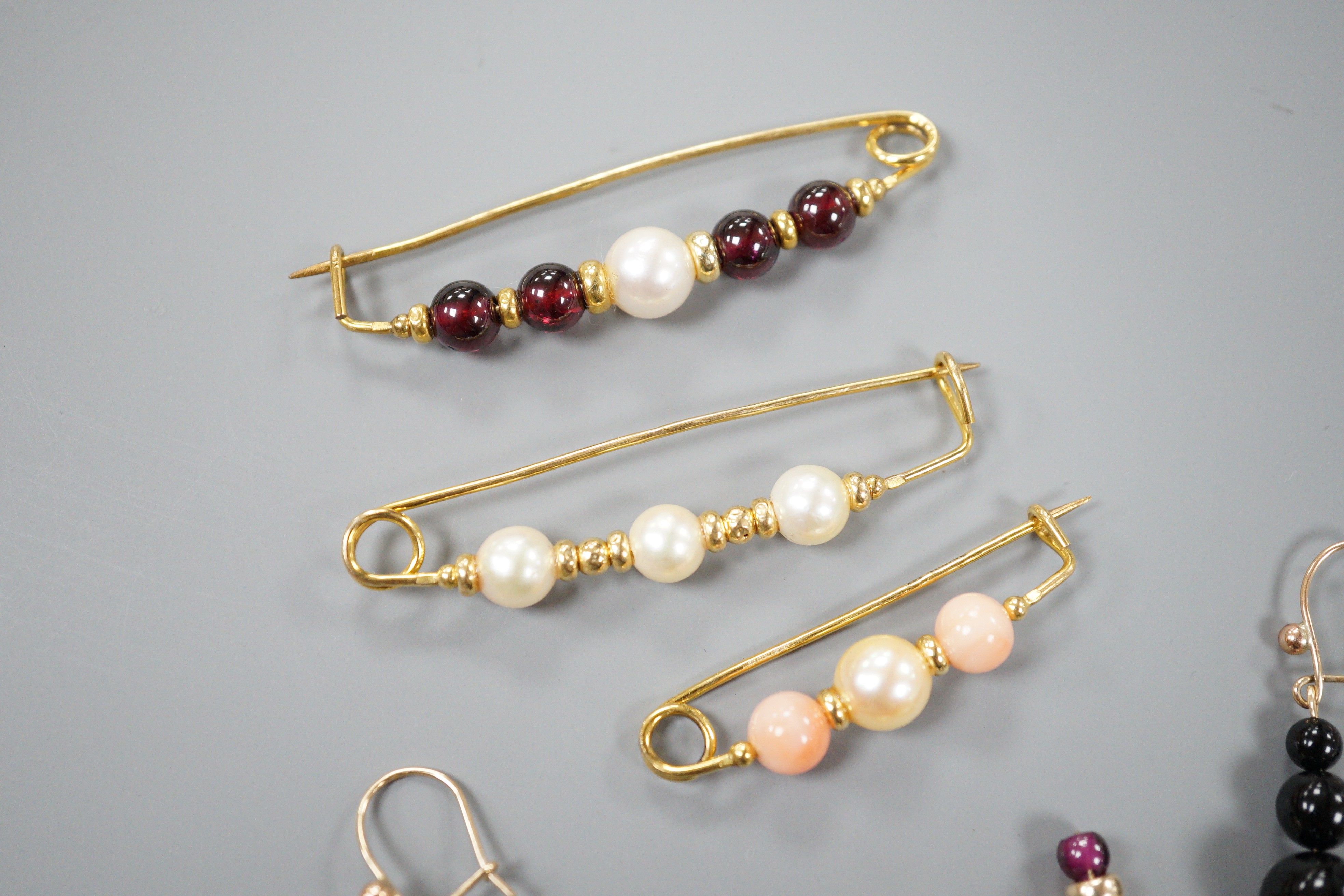 Three modern 9ct gold, cultured pearl and gem set brooches, largest 52mm and three modern pairs of yellow metal and gem set earrings, including hematite and 9k, gross weight 18.5 grams.